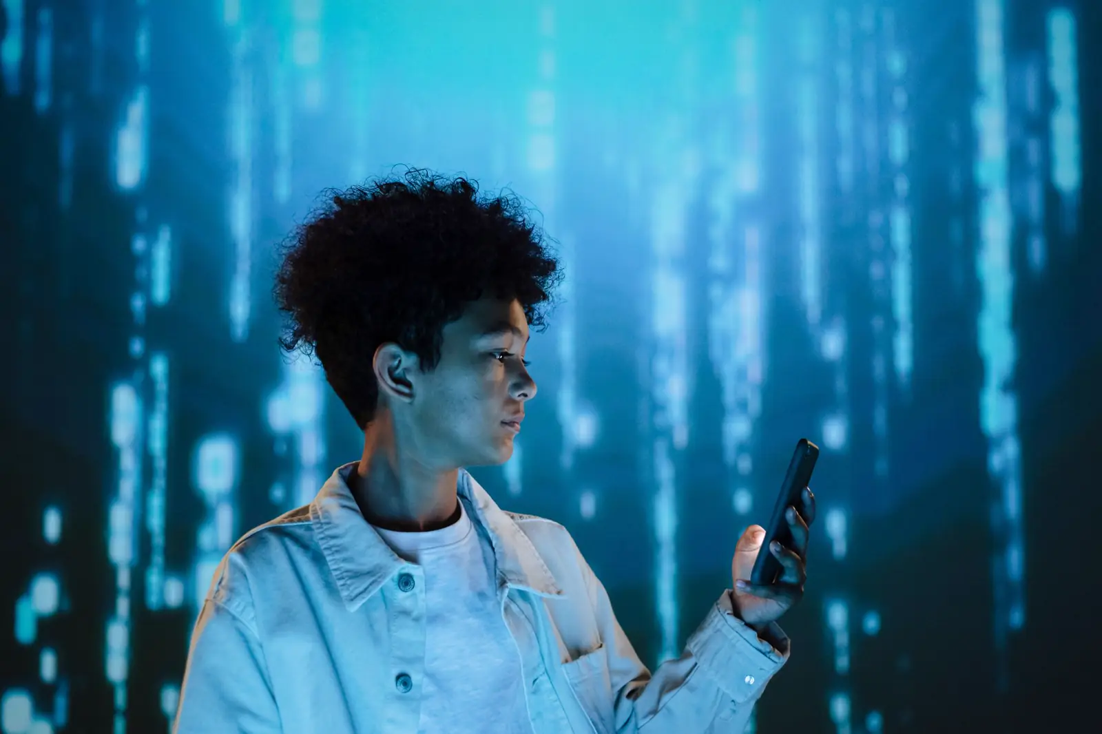 Teenager using a smartphone against a blue digital matrix background