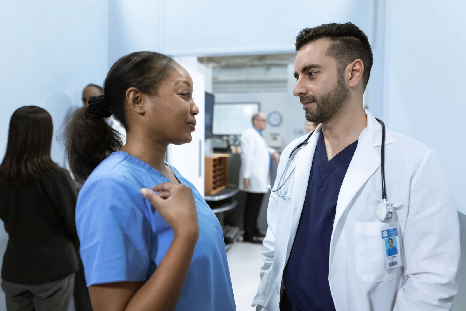 A nurse and a doctor talking in a hospital corridor